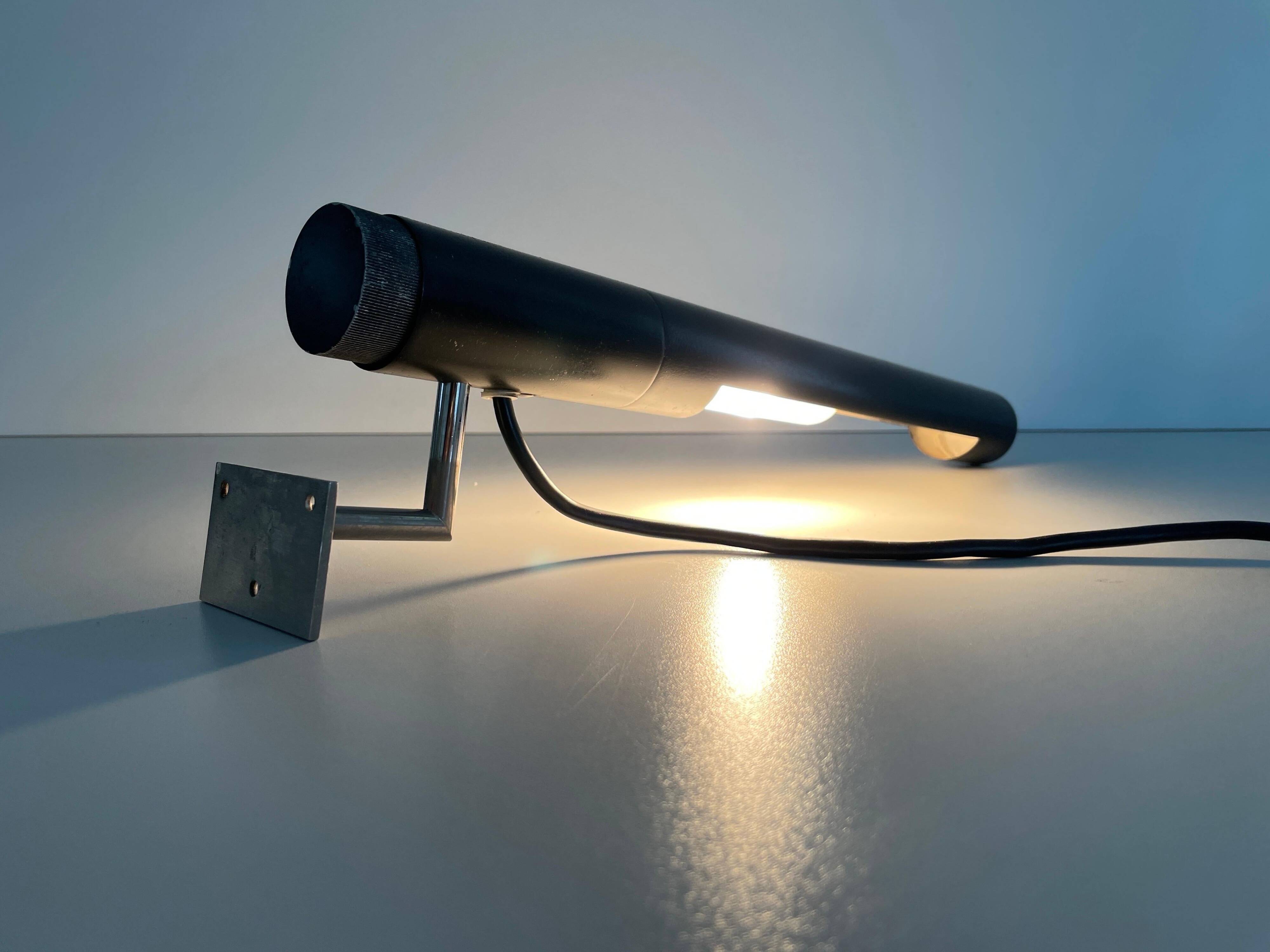 Minimalist black metal wall light with a cylindrical design, 1960s, Germany.