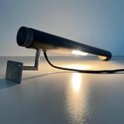 Minimalist black metal wall light with a cylindrical design, 1960s, Germany.