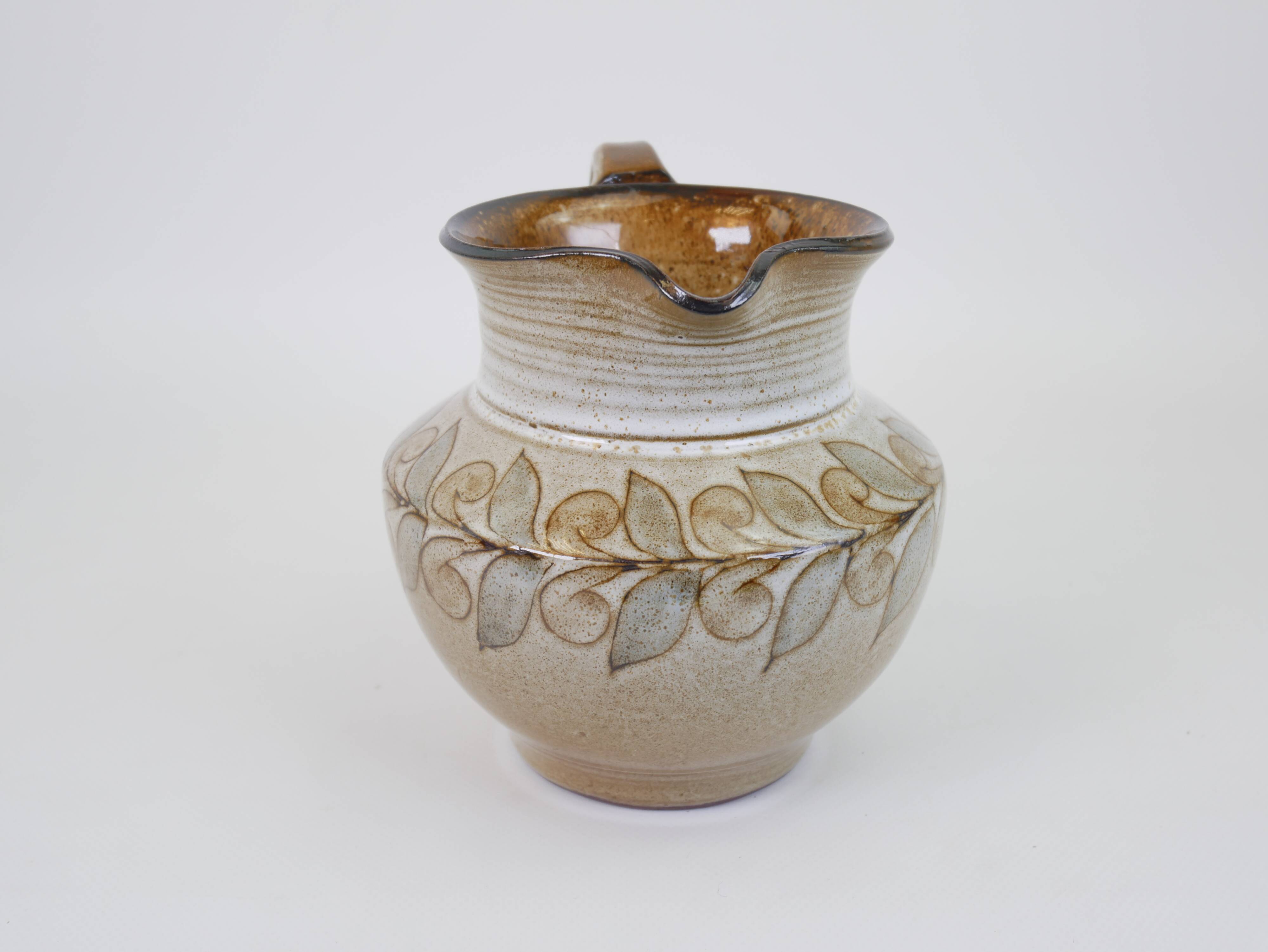 Glazed ceramic jug with plant decoration