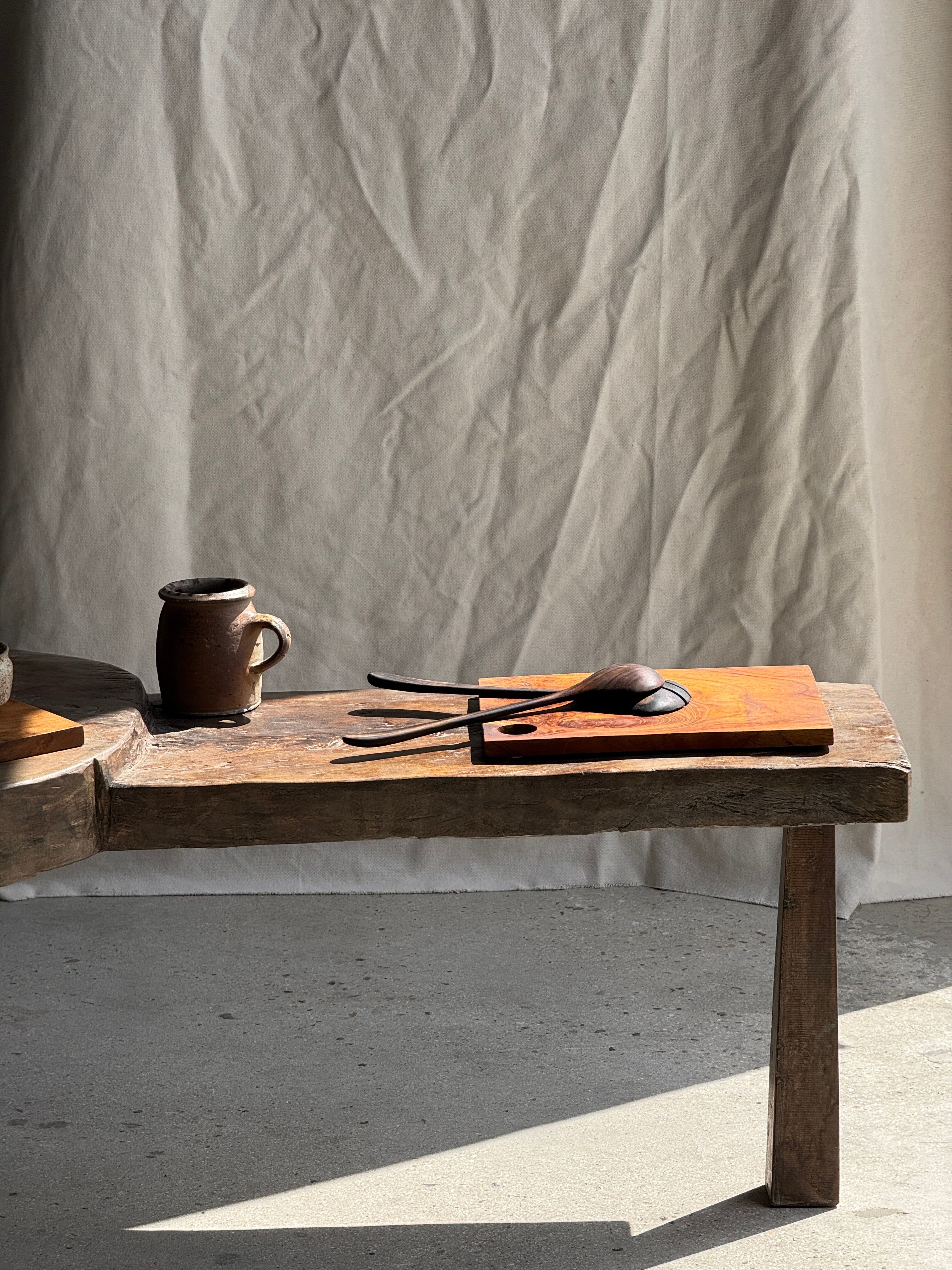 Small rectangular teak monoxyle cutting board with a circular handle.