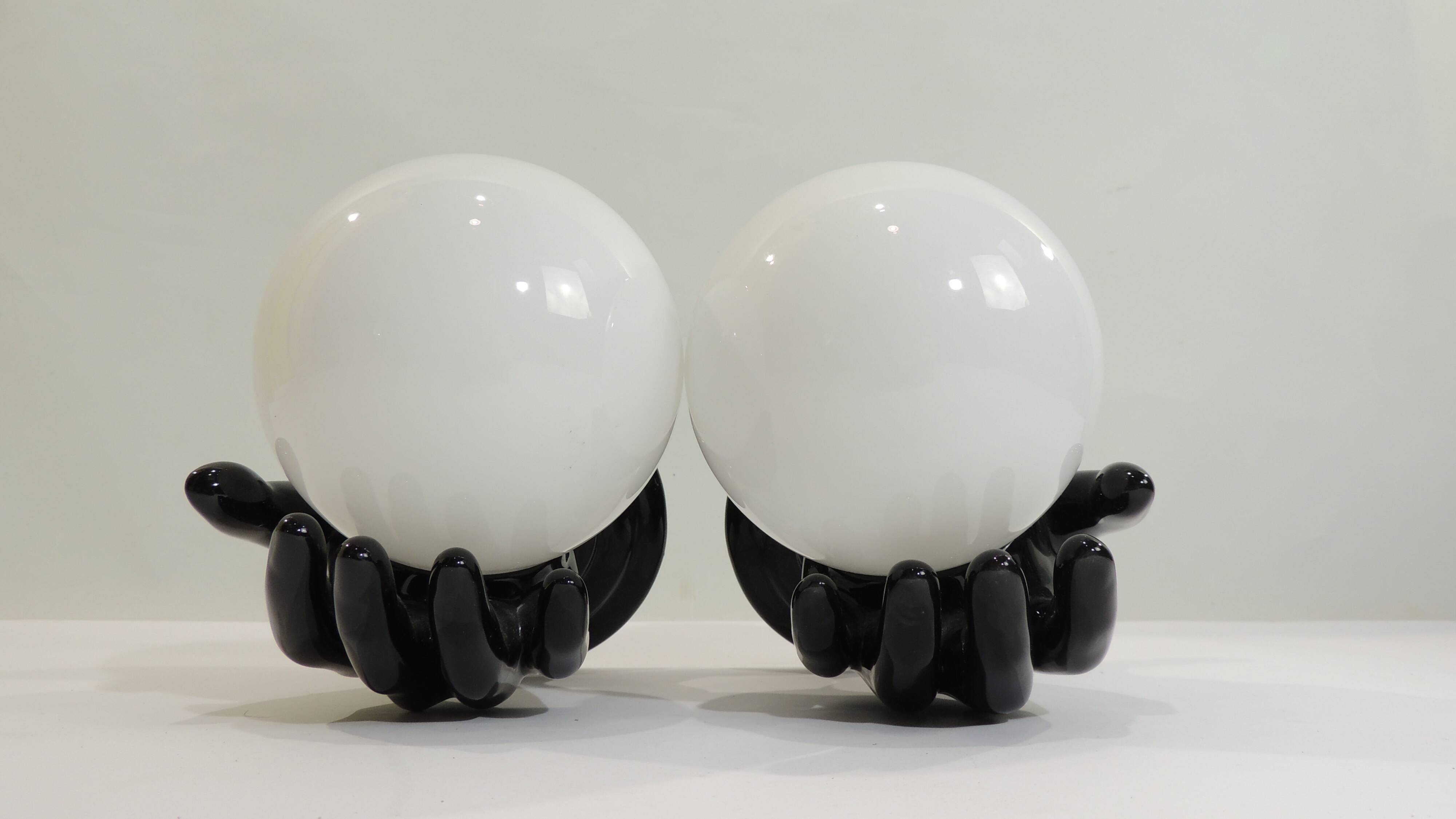 Paire d’appliques mains noires tenant un globe en opaline, années 70
