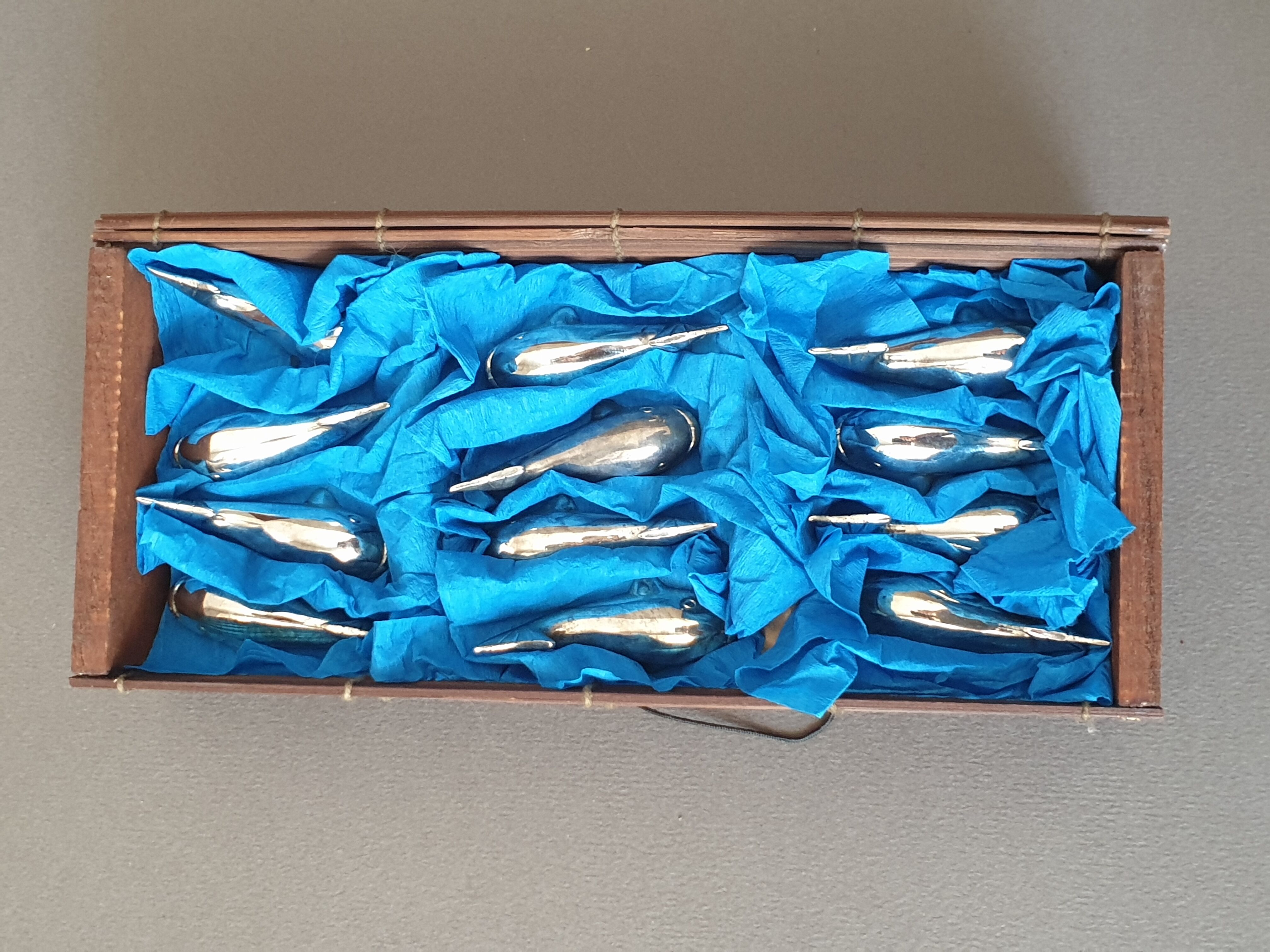 Lot 12 knife holders in the shape of a stylized whale or fish