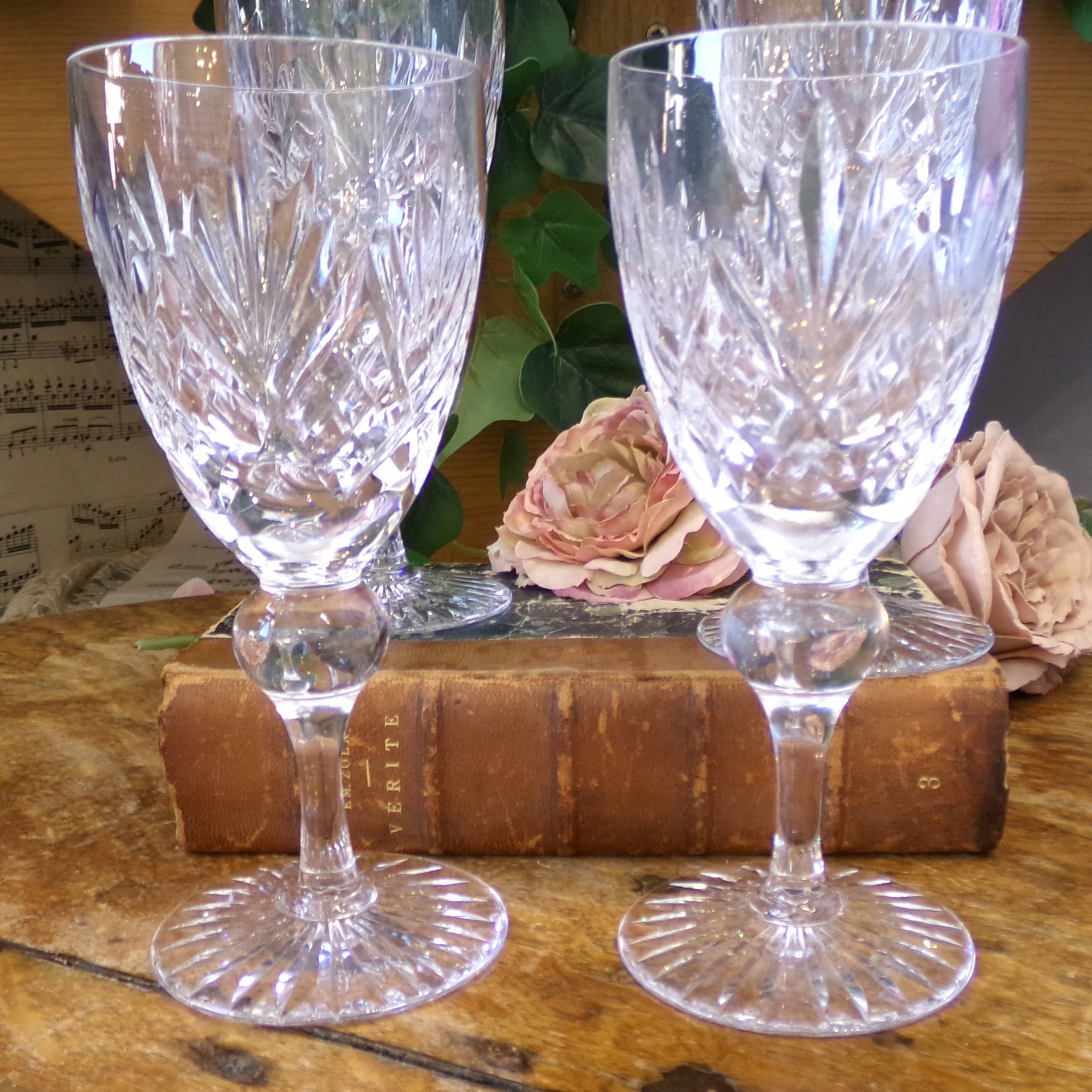 Cut crystal white wine glasses with a slender baluster-shaped stem.