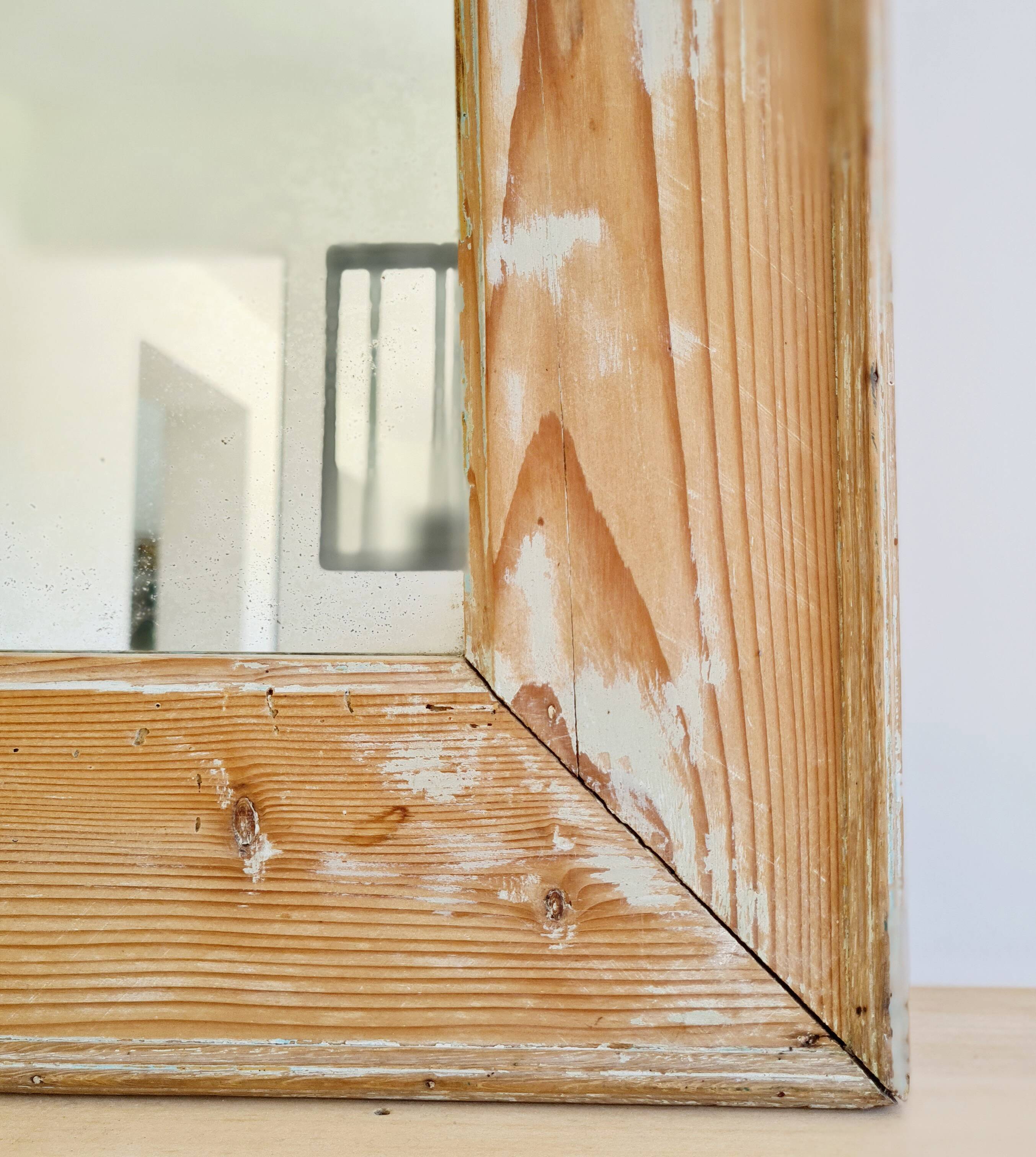 Antique mirror in raw wood with a patina and pediment.