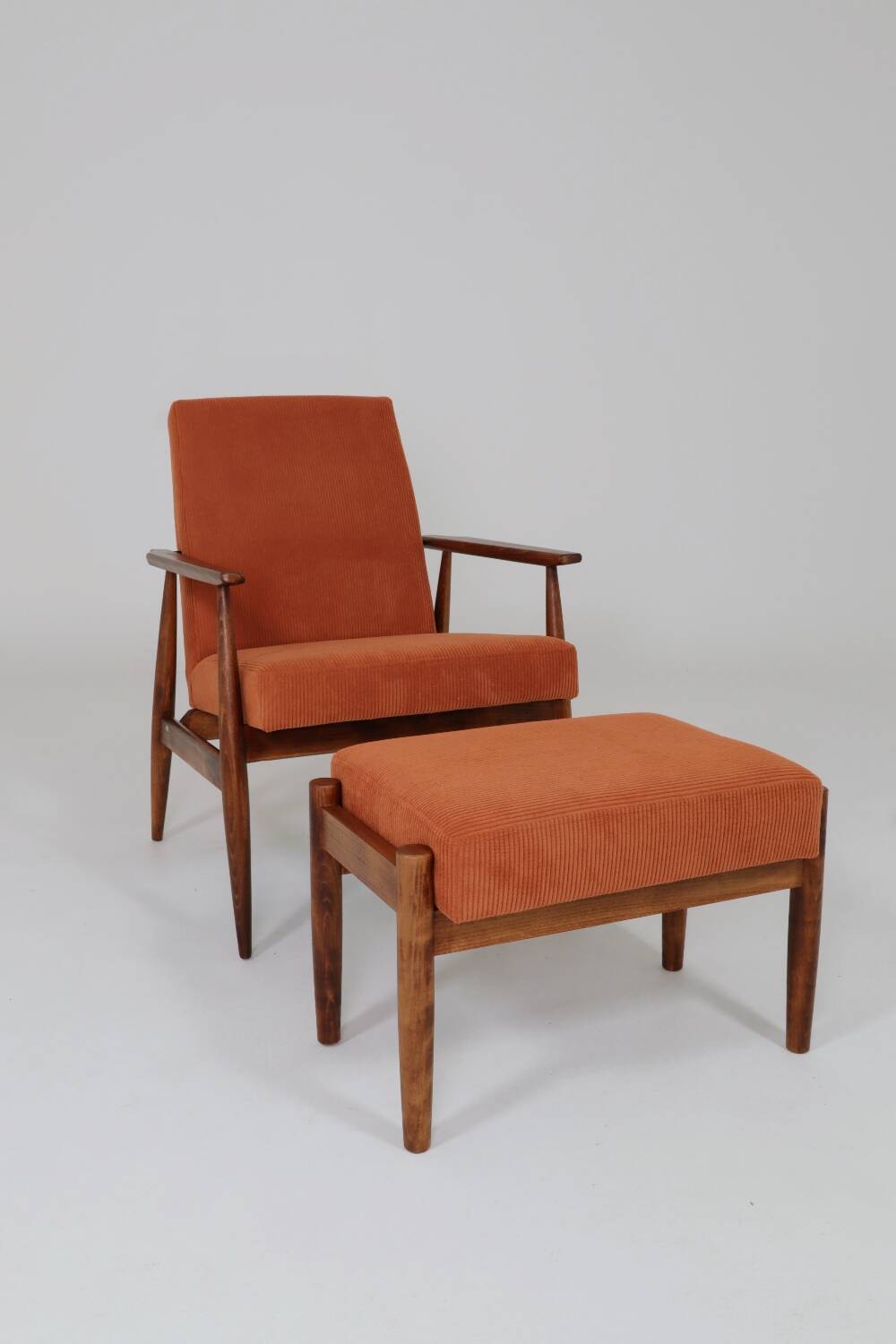 Vintage armchair and footrest in orange corduroy.