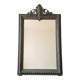 Antique mirror with a sculpted pediment in classic grey style.