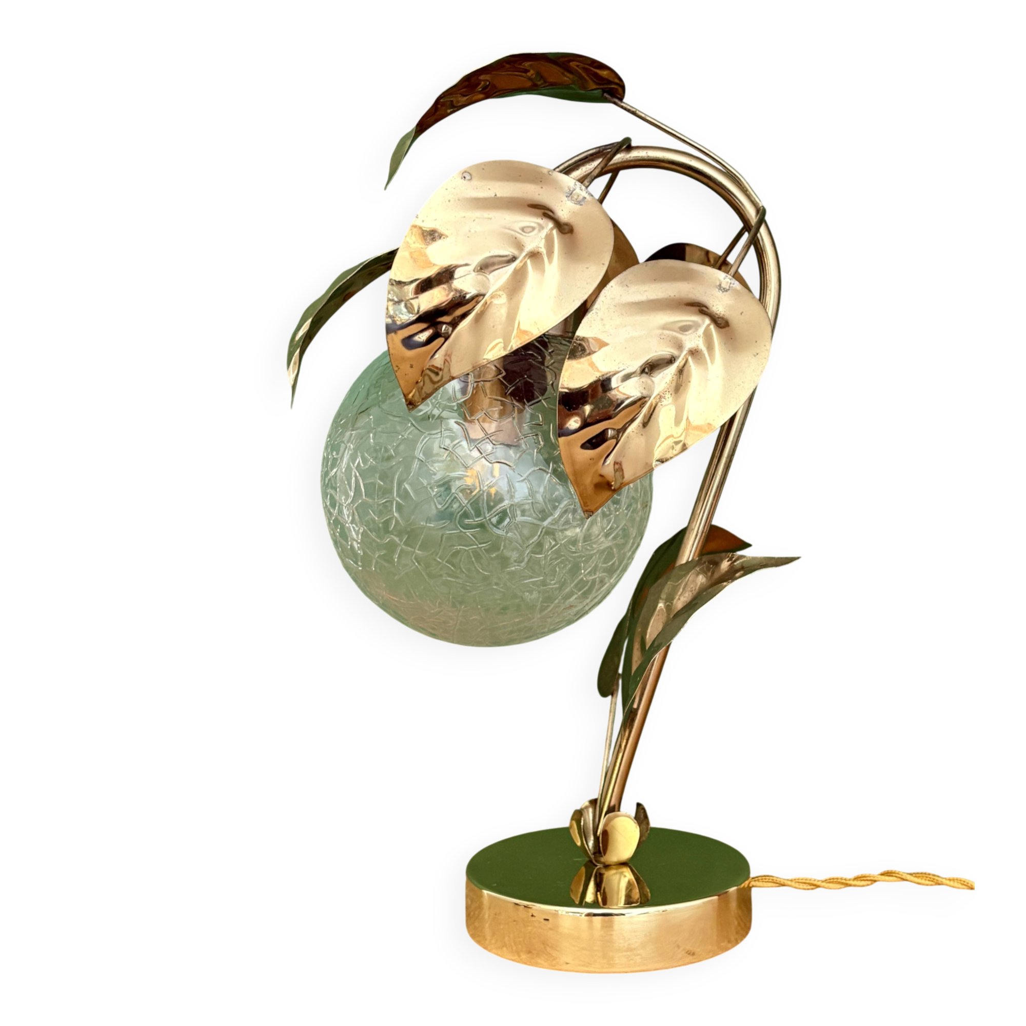 Vintage lamp with brass leaf design and transparent glass globe.