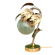 Vintage lamp with brass leaf design and transparent glass globe.