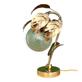 Vintage lamp with brass leaf design and transparent glass globe.