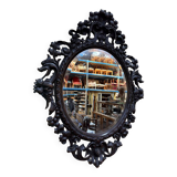 Oval mirror in carved wood with dragon heads.