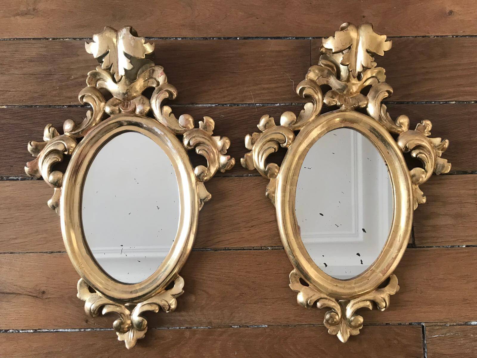 Paire de miroirs rococo dorés en bois sculpté