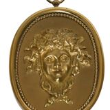 Pair of wall sconces with a relief decoration of a Bacchus mask.