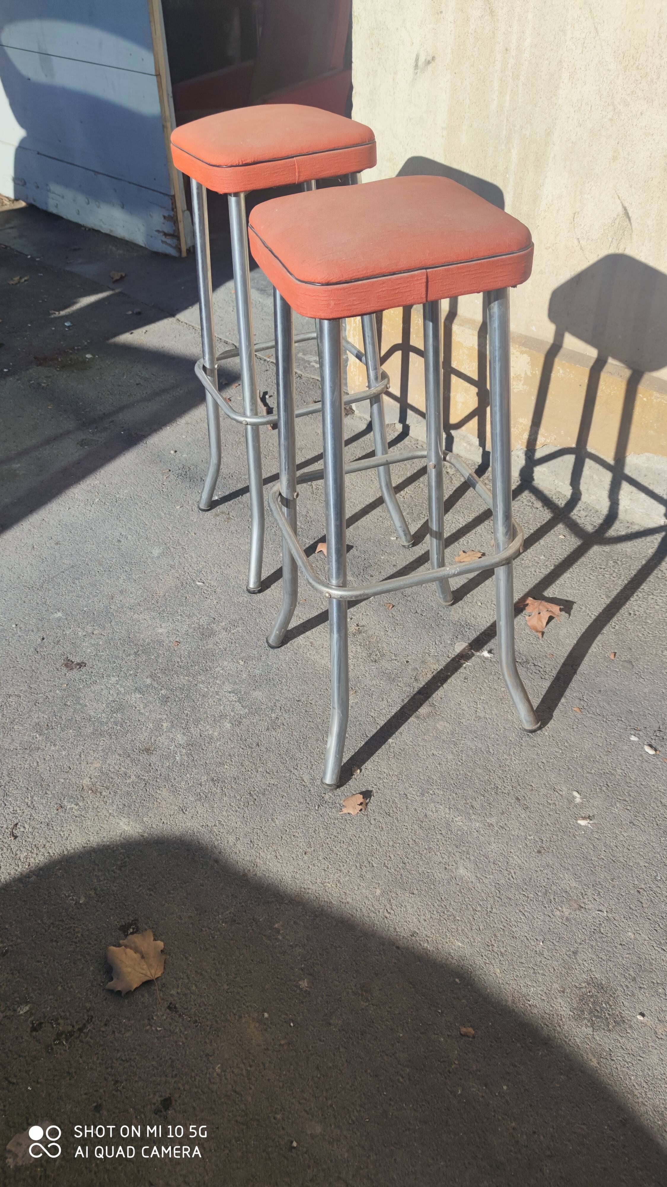 Pair of aluminum bar stools with orange and black seats