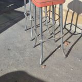 Pair of aluminum bar stools with orange and black seats