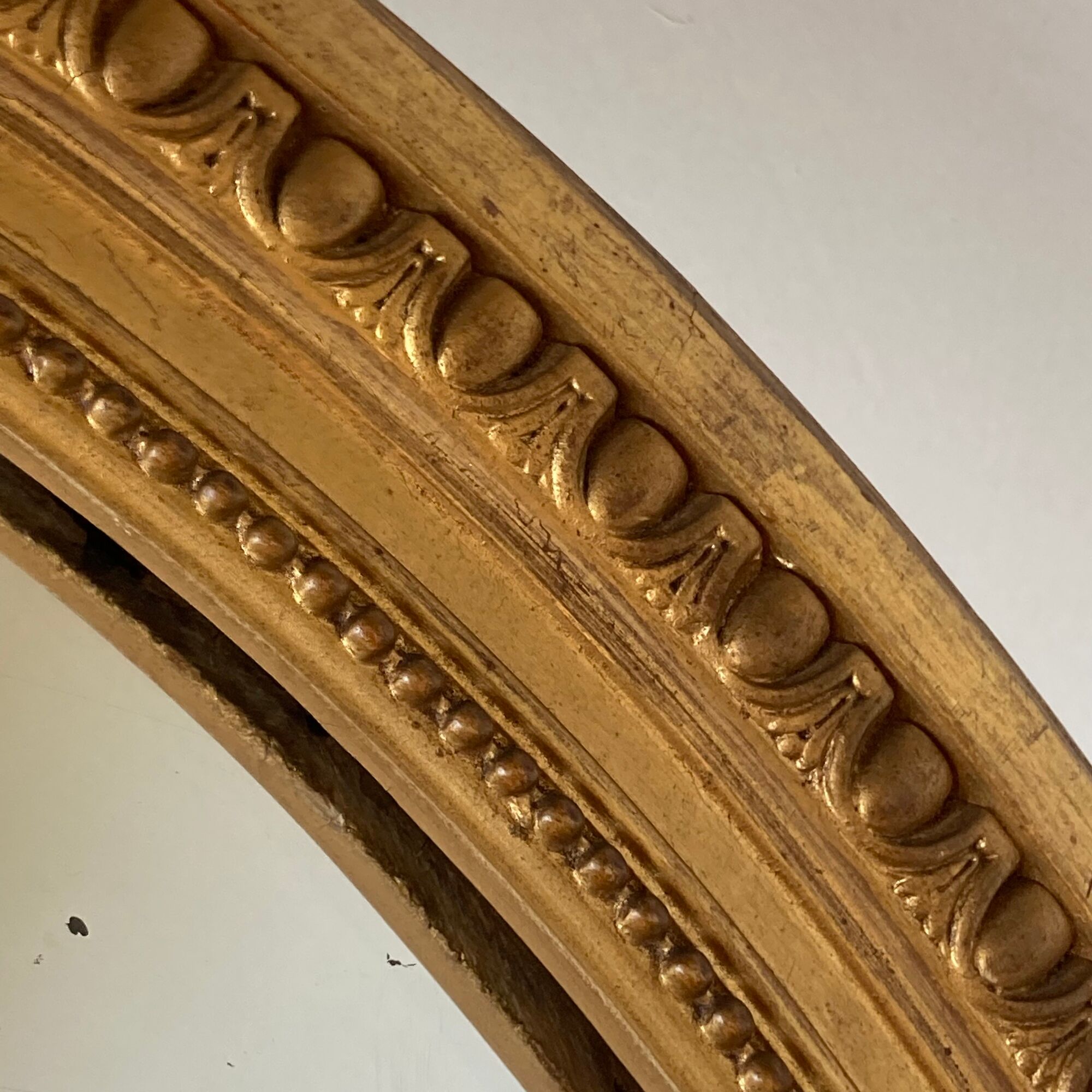 Oval mirror in carved wood, stuccoed and gilded with leaf Louis XVI style late nineteenth century
