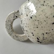 Small speckled ceramic jug in a vintage workshop style.