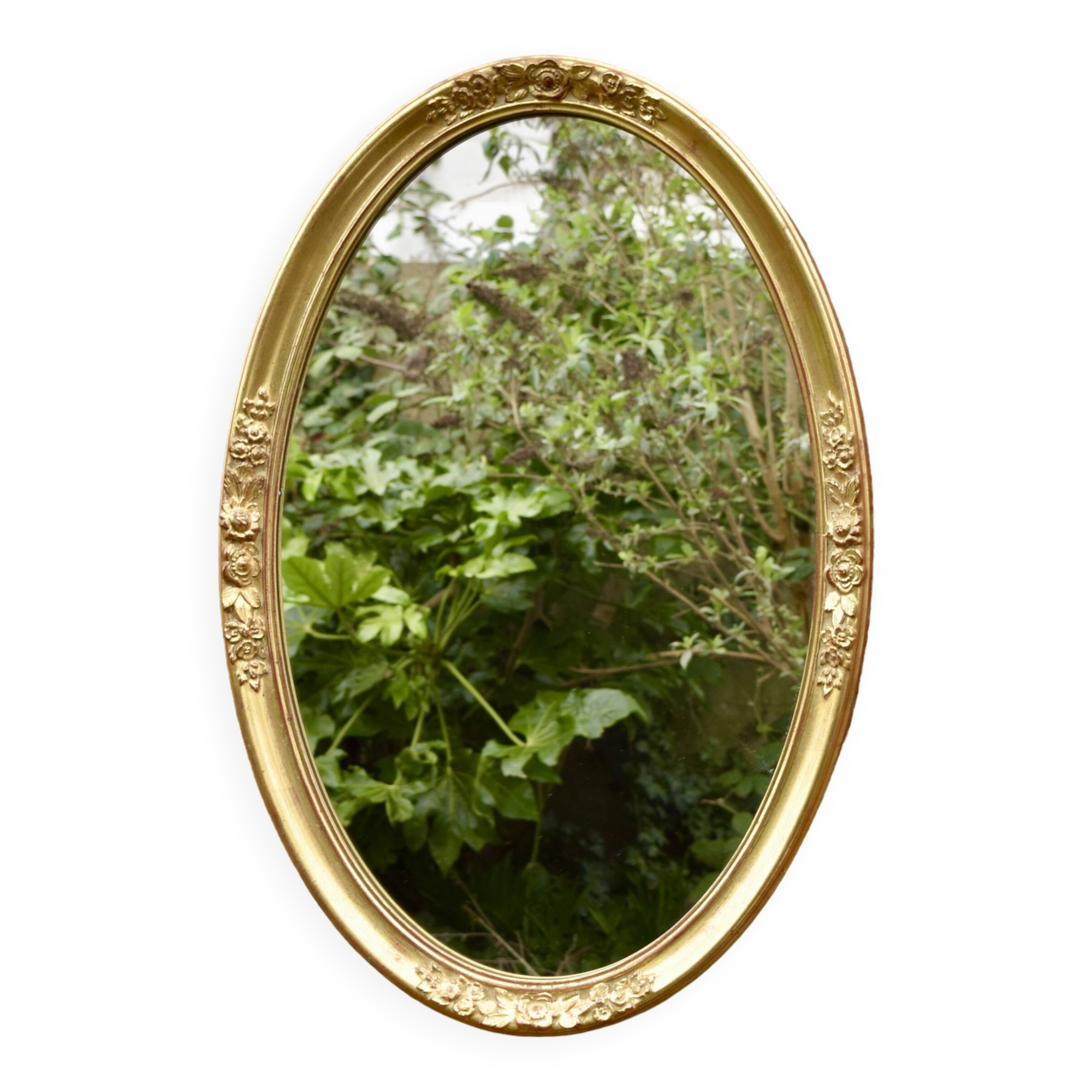 Old large oval wall mirror in golden resin