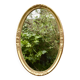 Old large oval wall mirror in golden resin
