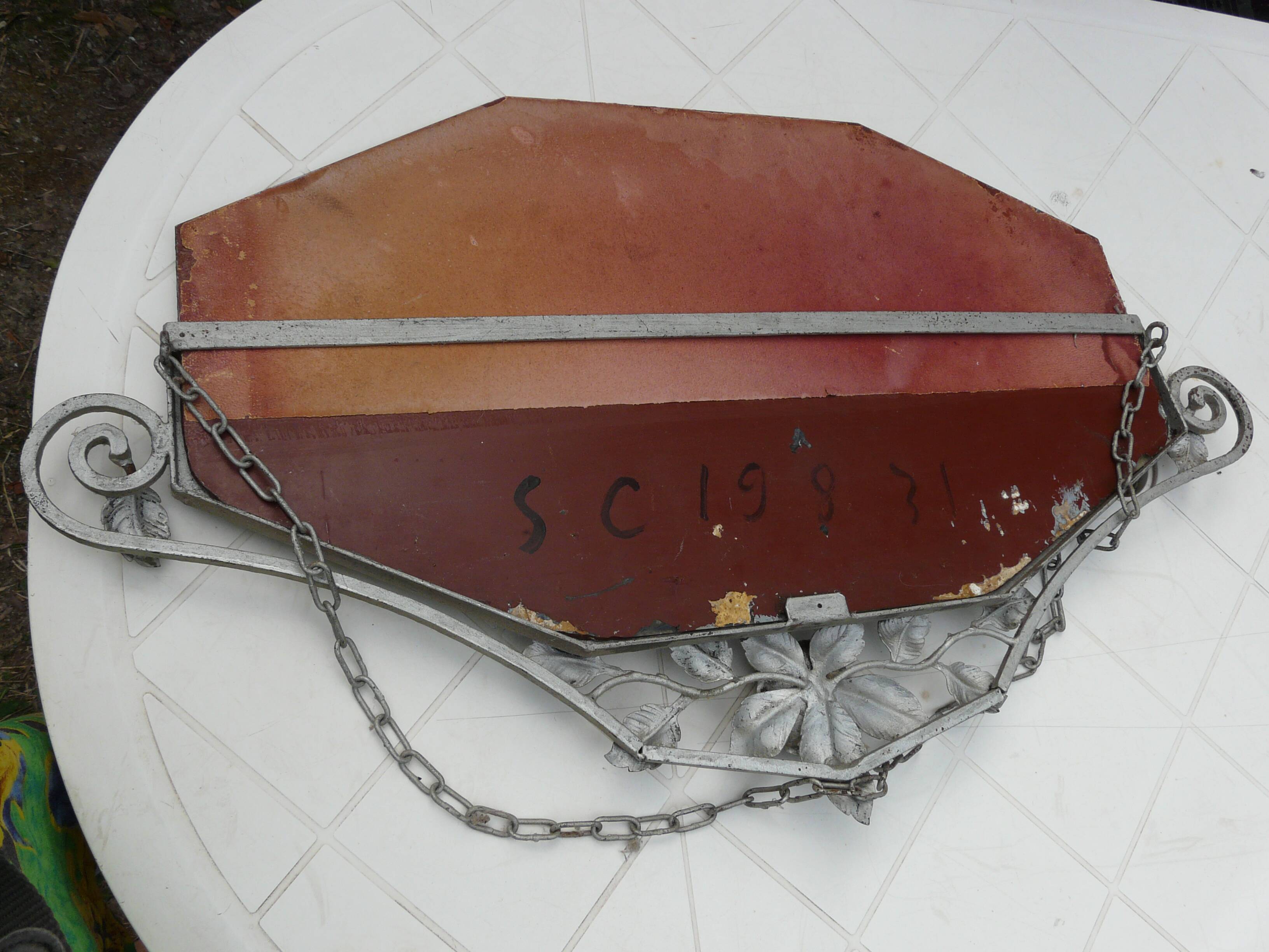 Beveled mirror with art-deco wrought iron frame and floral decor with hanging chain