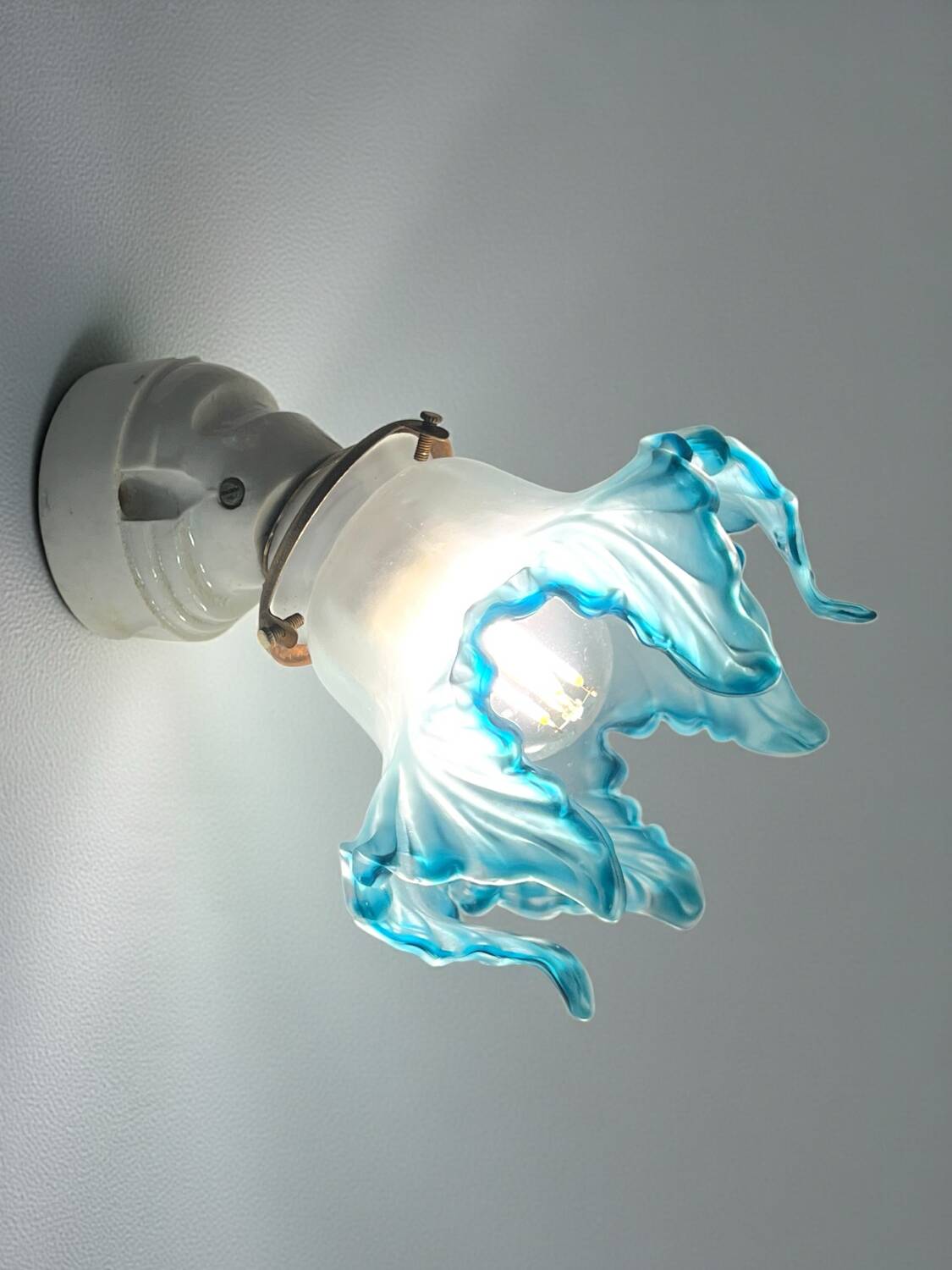 Pair of wall lights with porcelain feet and blue glass tulips in Art Deco style.