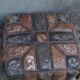 Set of 2 vintage ottomans in brown and black leather with Egyptian patterns from the 1970s.