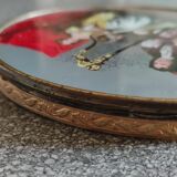 Old round box with decoration fixed under glass