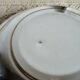 Shallow round metal plate with pearl bead decoration.