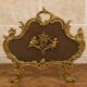 Large gilded bronze fireplace screen decorated with putti and rocaille motifs.