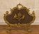 Large gilded bronze fireplace screen decorated with putti and rocaille motifs.