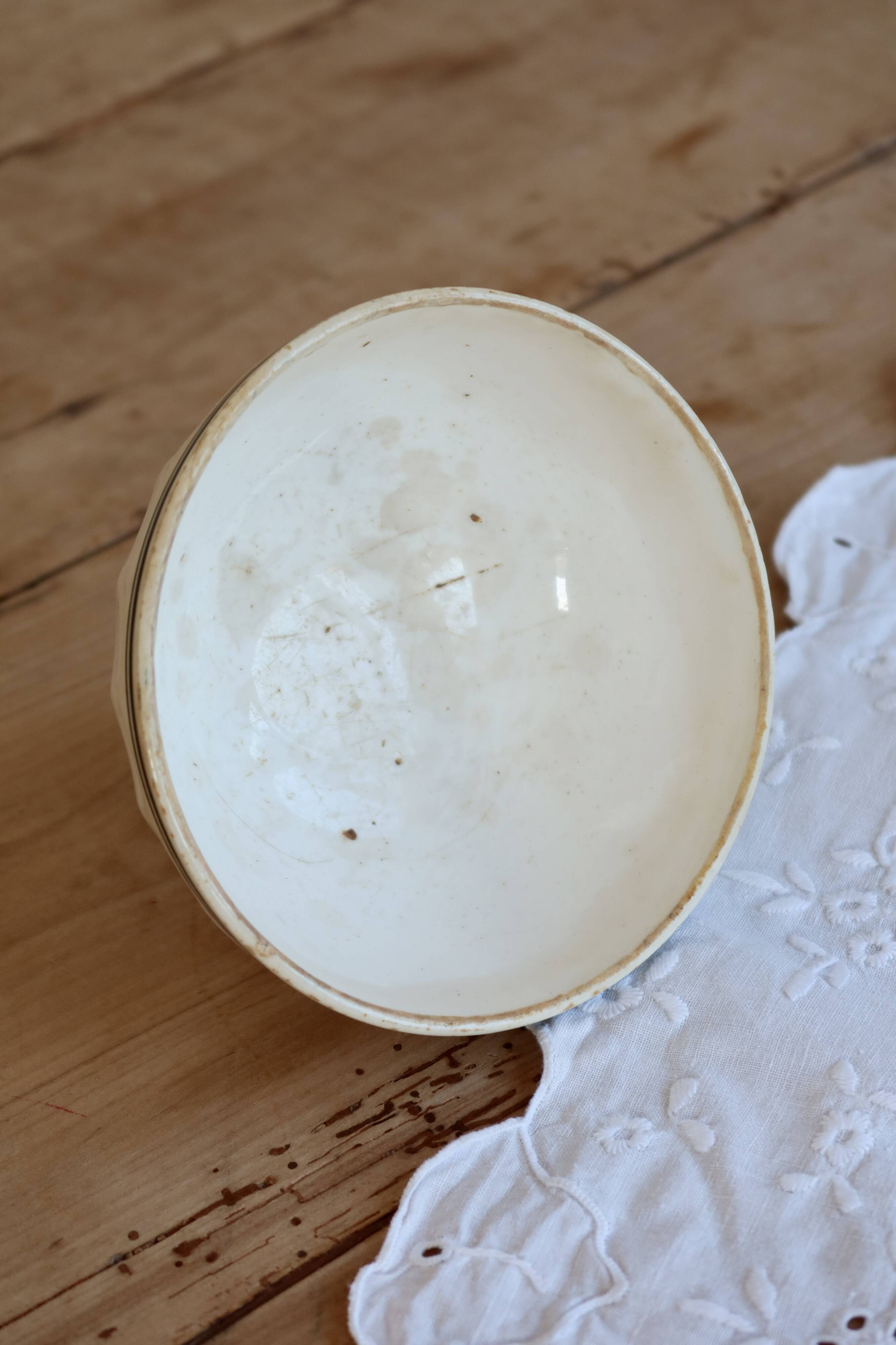 Old ivory ceramic bowl with double green trim.