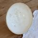 Old ivory ceramic bowl with double green trim.