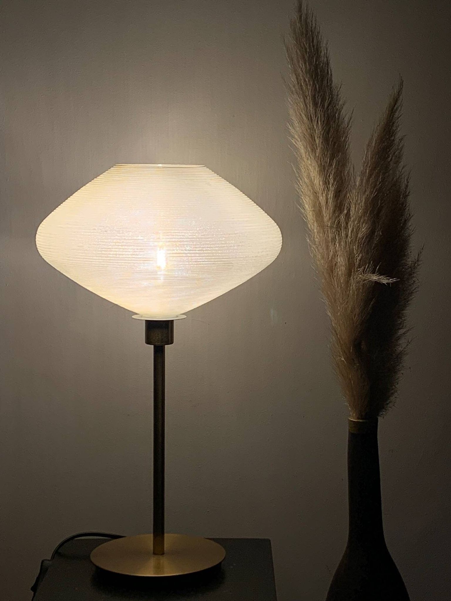 Table lamp with a vintage glass globe and saucer and a golden foot
