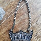 Chiseled glass whiskey decanter and its necklace marked “whiskey”