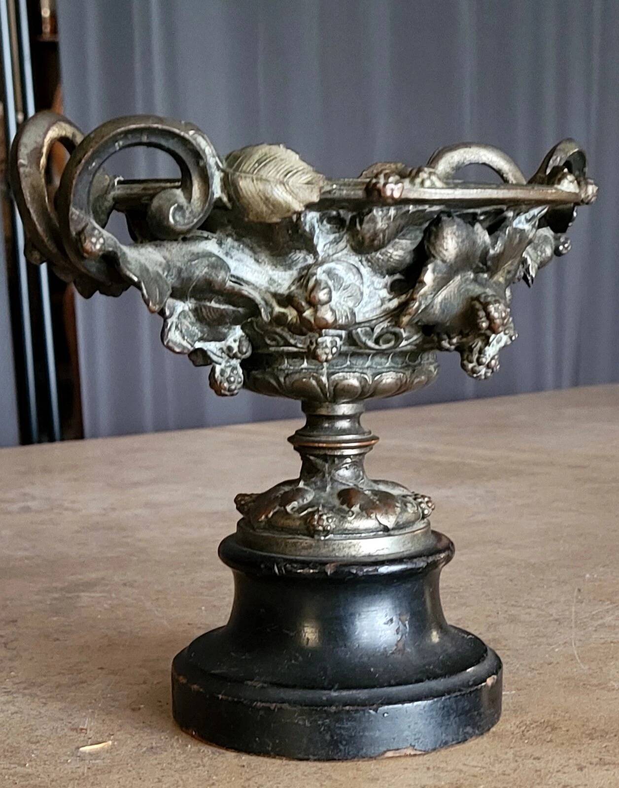 Patinated bronze cup, richly decorated with foliage and bunches of grapes