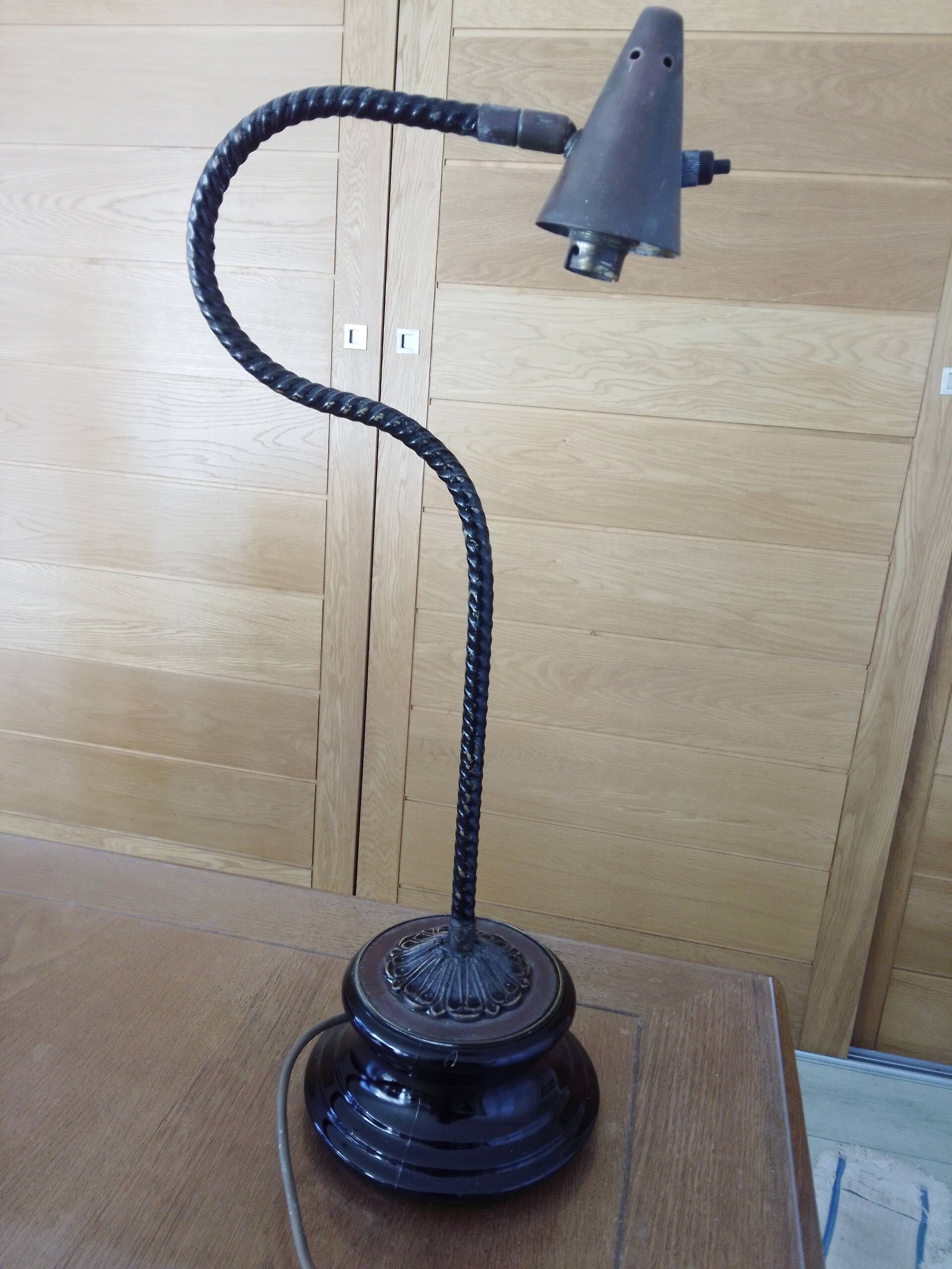 Old desk lamp with a small copper shade and a porcelain base.