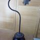 Old desk lamp with a small copper shade and a porcelain base.