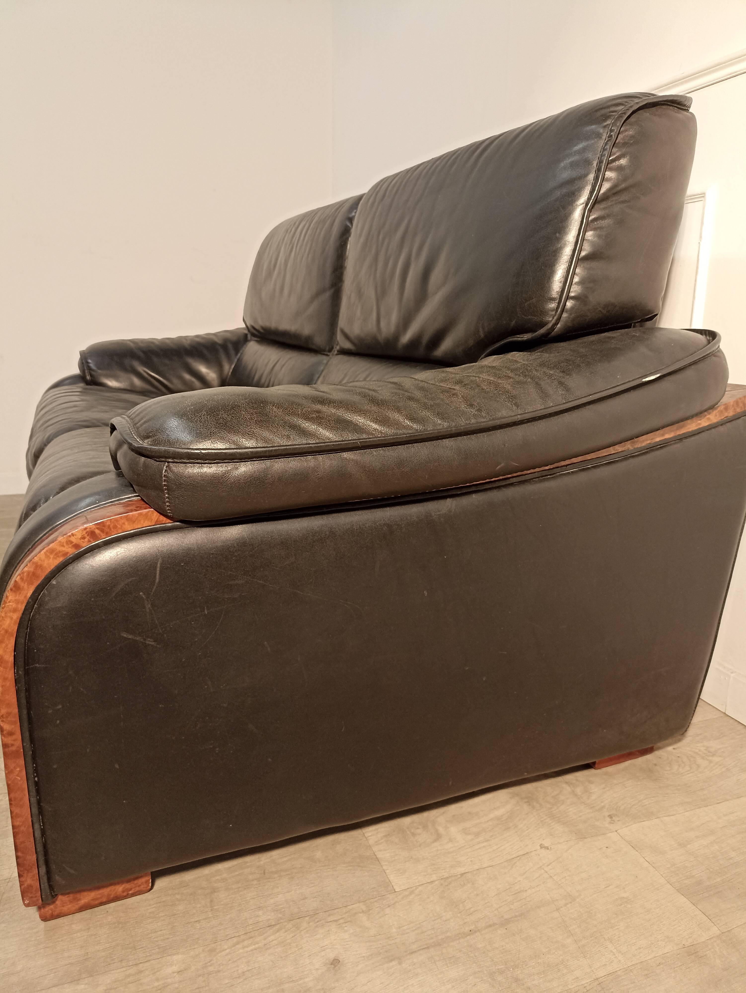 Black leather sofa and wooden armrests