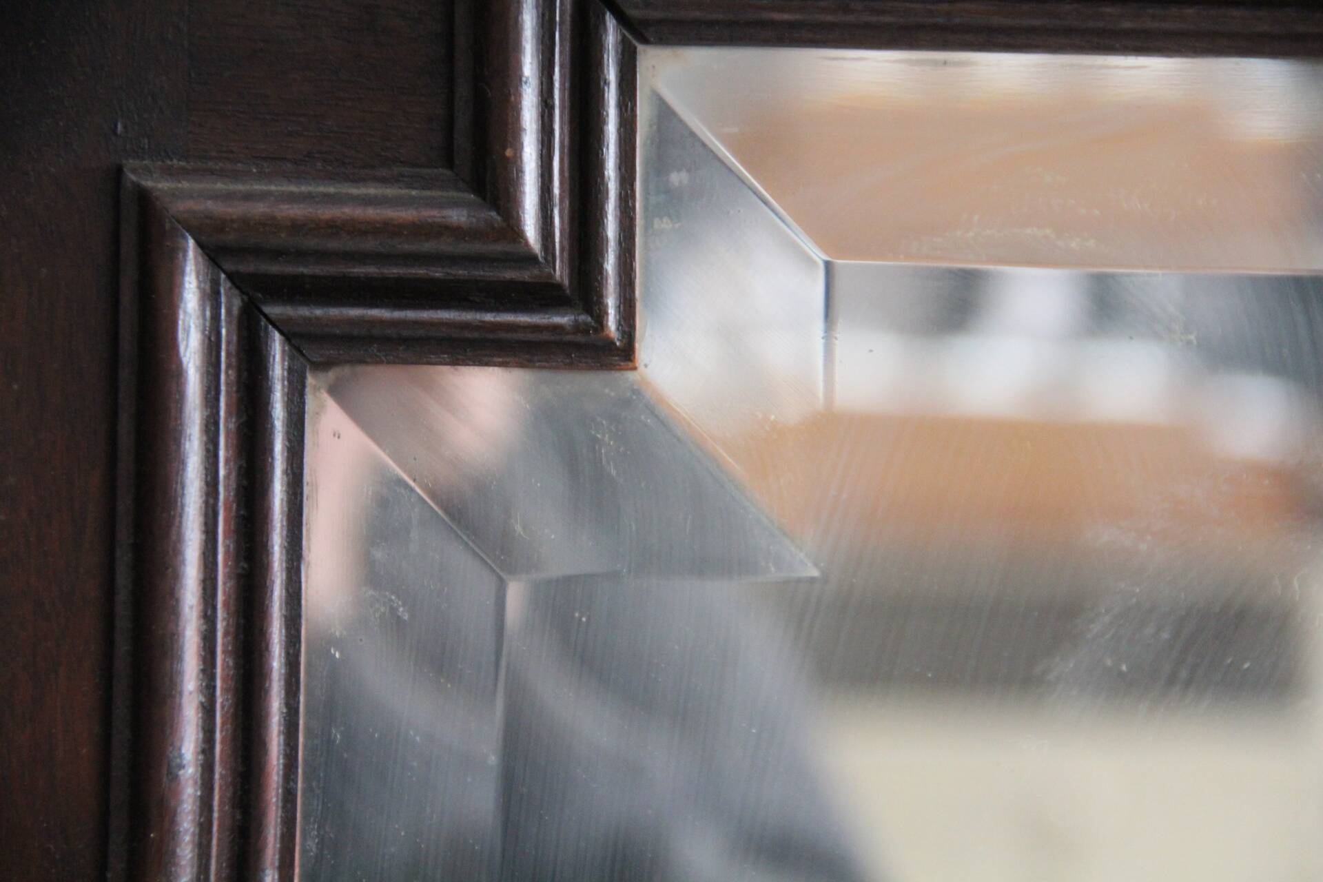 Imposing beveled mirror with wooden frame