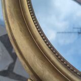Ovoid mirror with double pediments gilded with leaf circa 1830, 105x66 cm