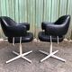 Pair of vintage armchairs in black skai with metal legs.