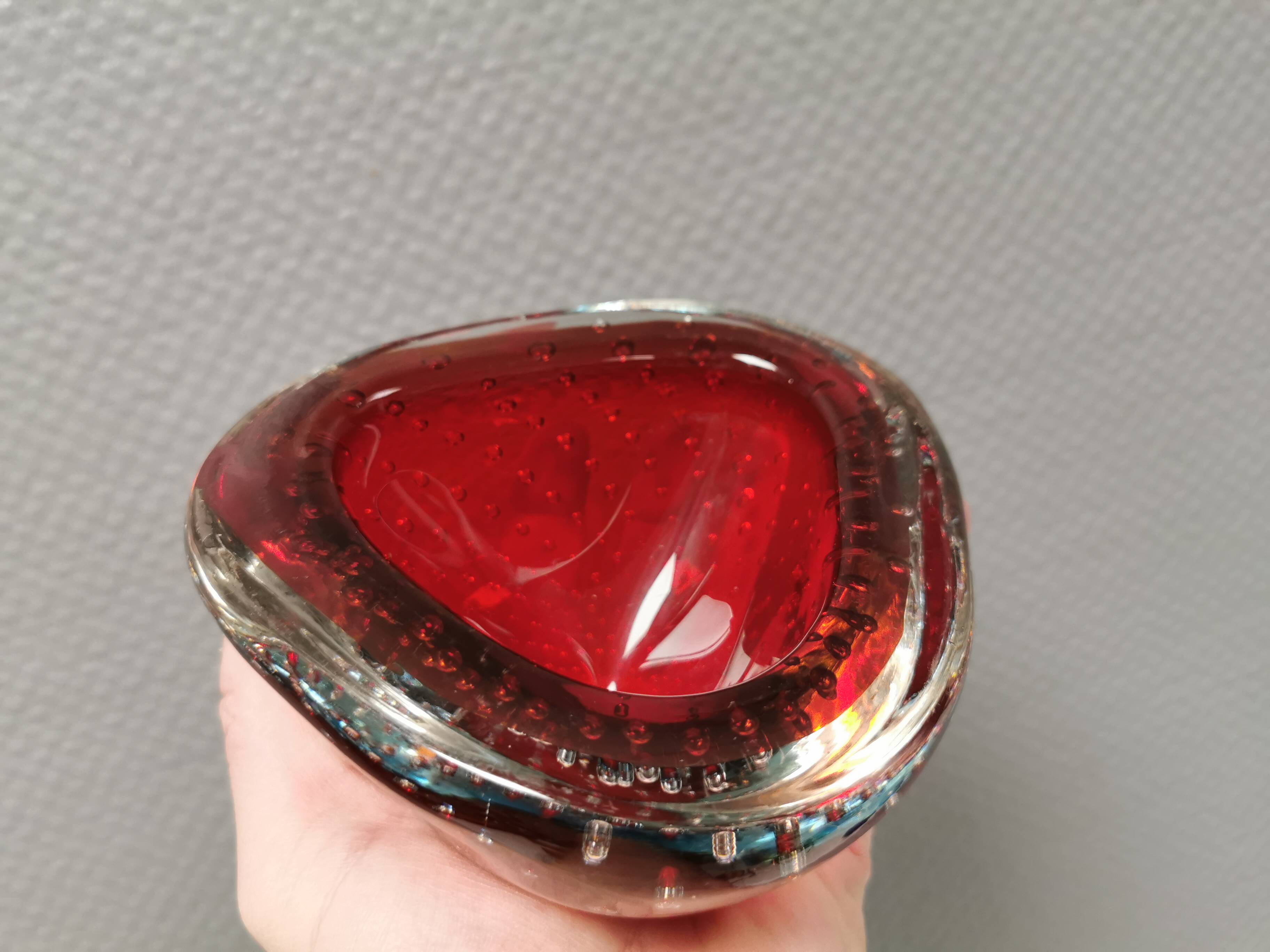 Small glass bowl in beautiful emerald red color with inlaid bubbles.