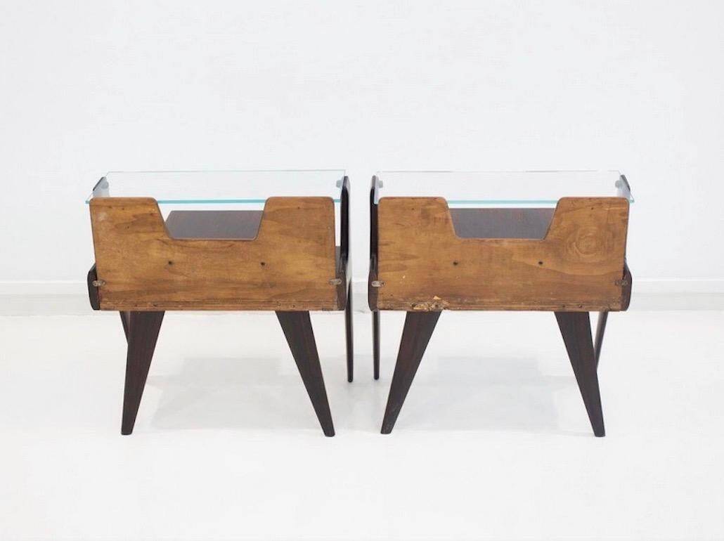 Pair of modernist Italian bedside tables in wood with a glass top.