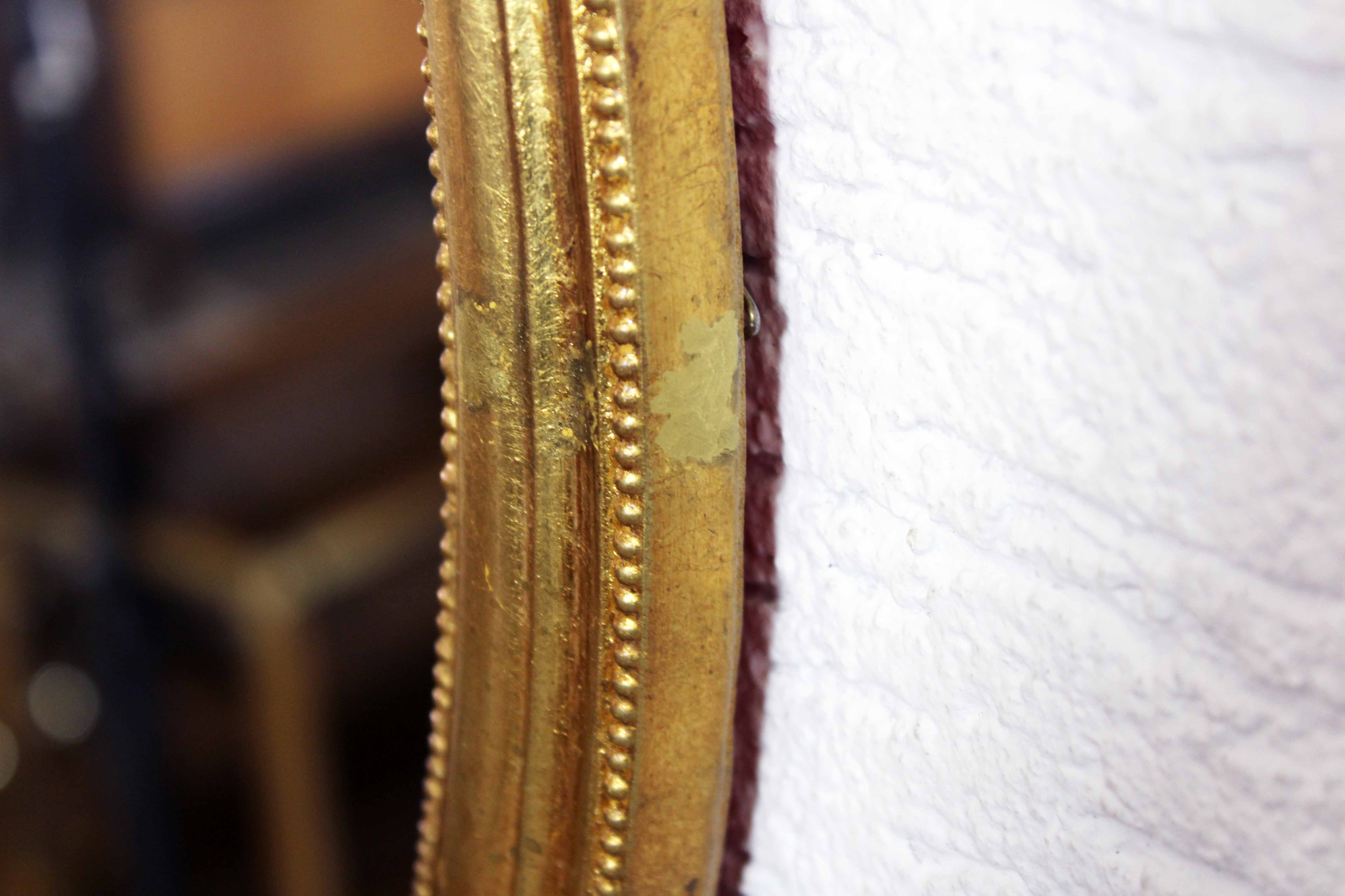 Golden oval mirror with leaf
