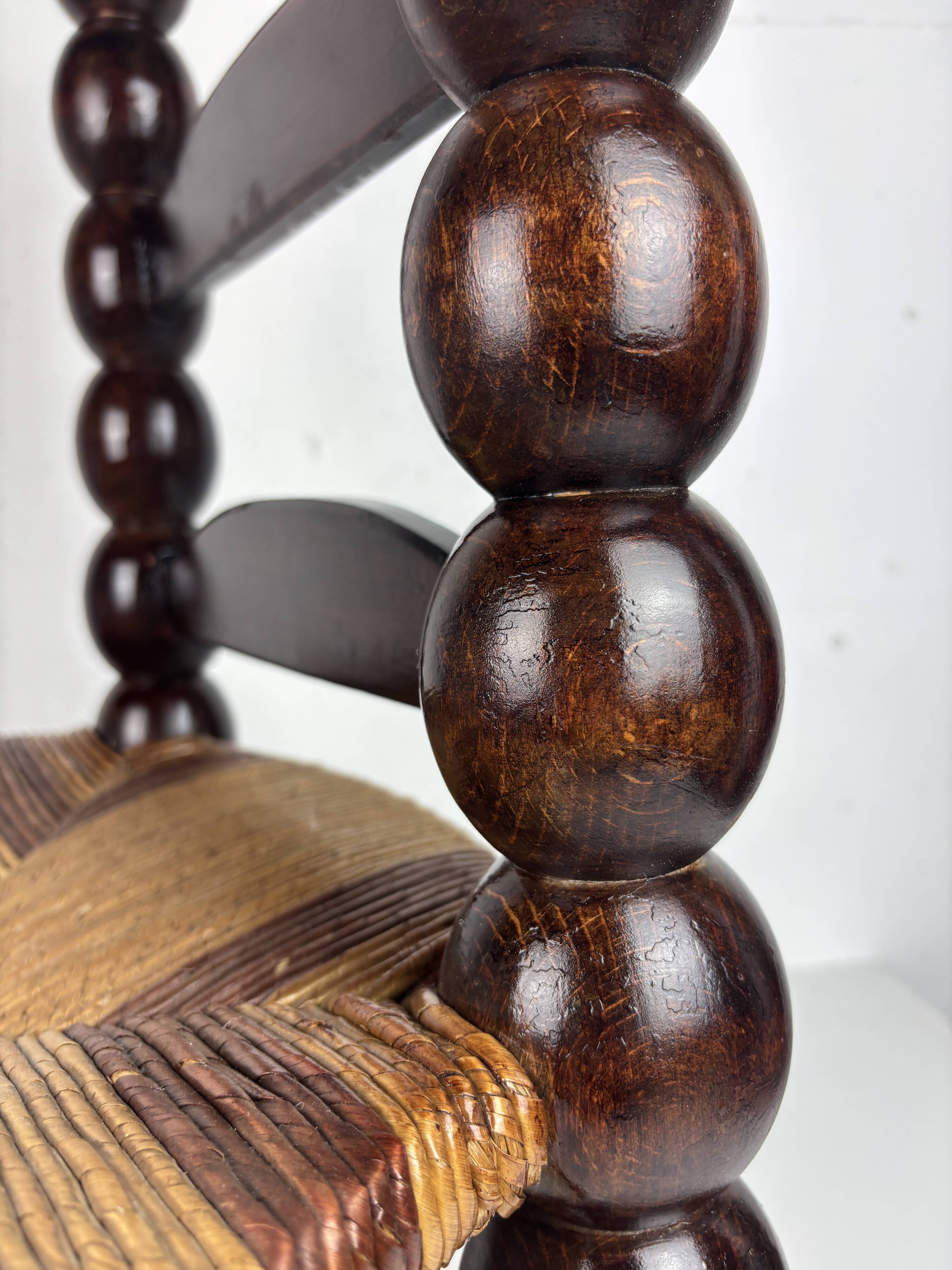 Brutalist wood turned bobbin low rush chair n the style of Charles Dudouyt