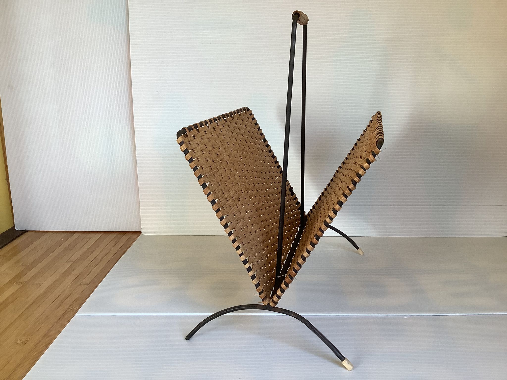 Old magazine rack in straw and black metal