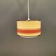 Hanging lamp with brass-coloured details, made of fabric with intact plastic bottom grille.