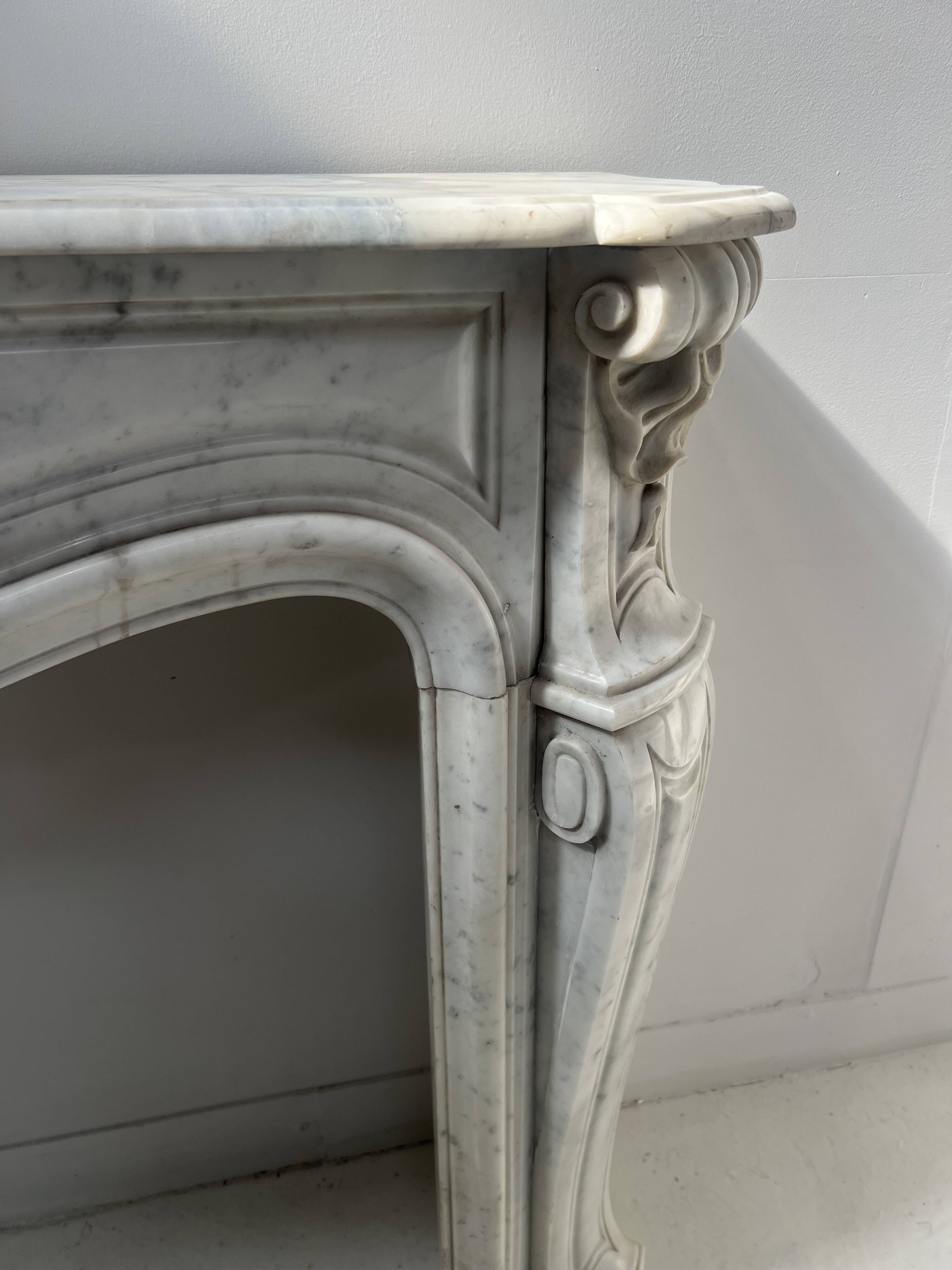 Louis XV style fireplace in veined white Carrara marble, 19th century.
