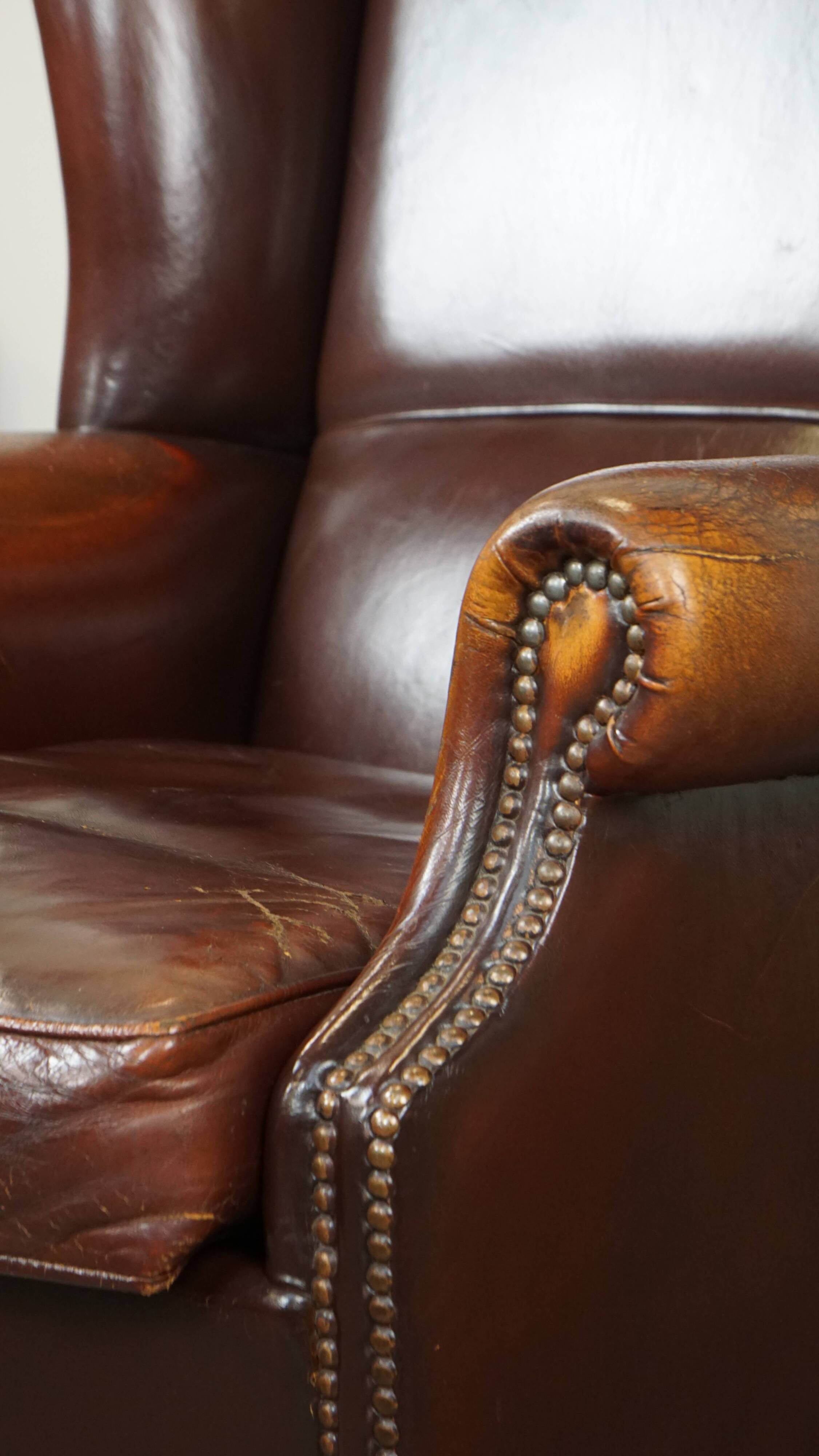 Dark English style sheepskin wingback chair with character and patina