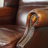 Dark English style sheepskin wingback chair with character and patina