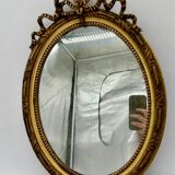 Antique oval gilded mirror with wooden frame and stucco detail